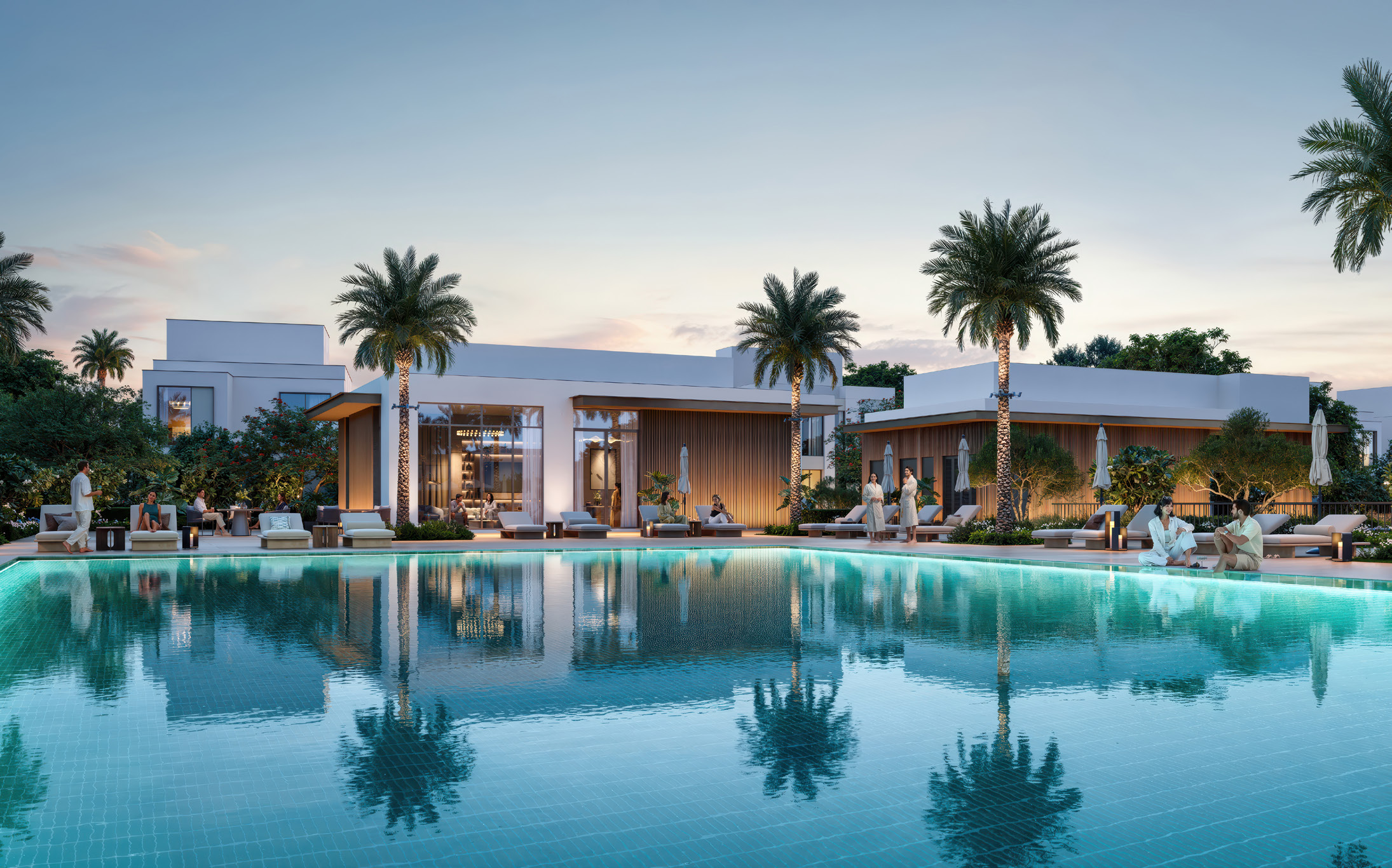 Community pool with sun loungers in front of the clubhouse at dusk