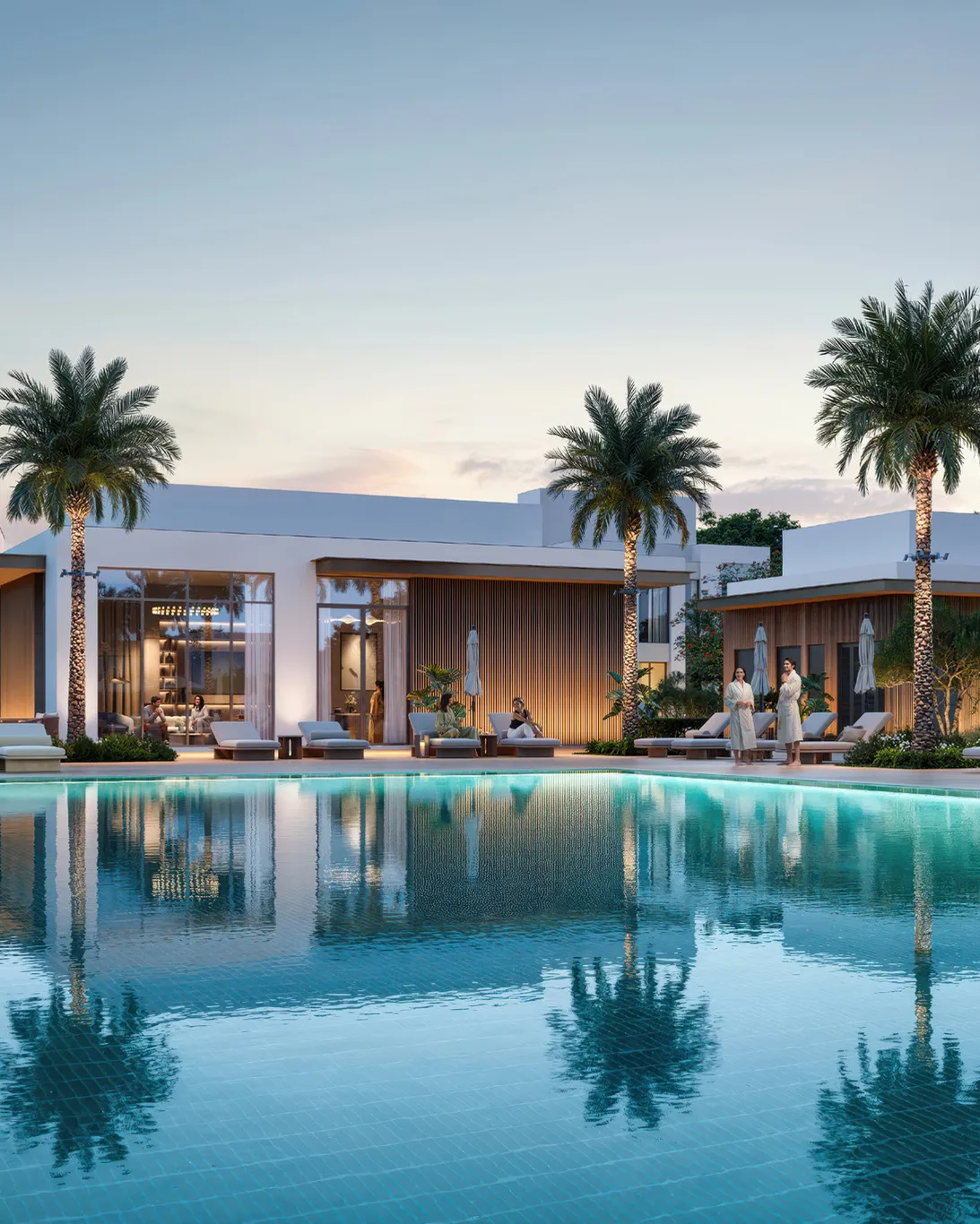 Community pool with sun loungers in front of the clubhouse at dusk