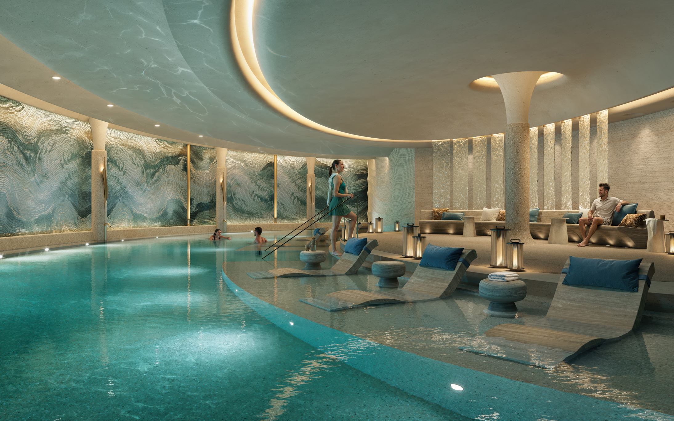 Softly lit indoor pool with loungers set into shallow water
