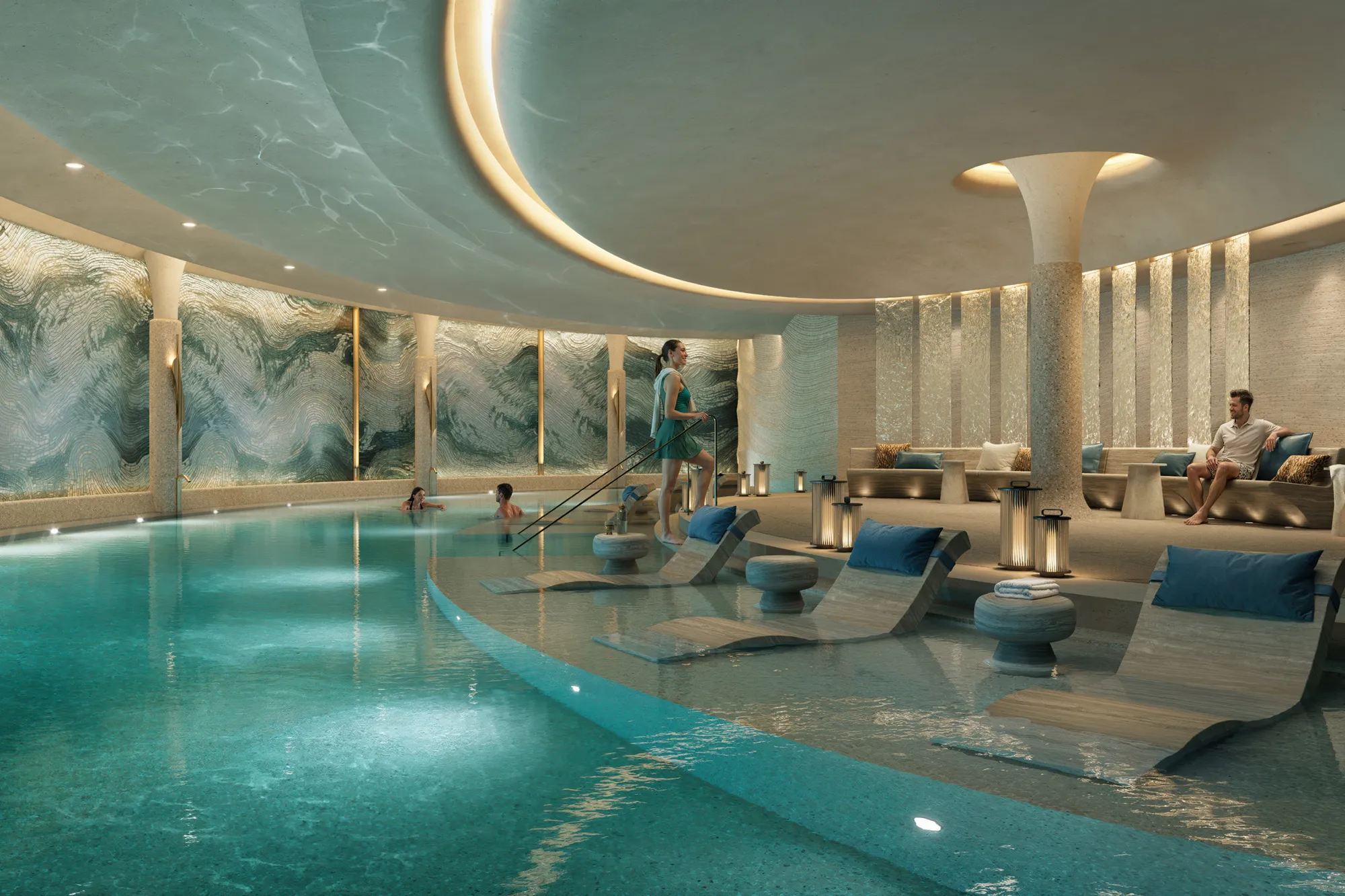 Softly lit indoor pool with loungers set into shallow water
